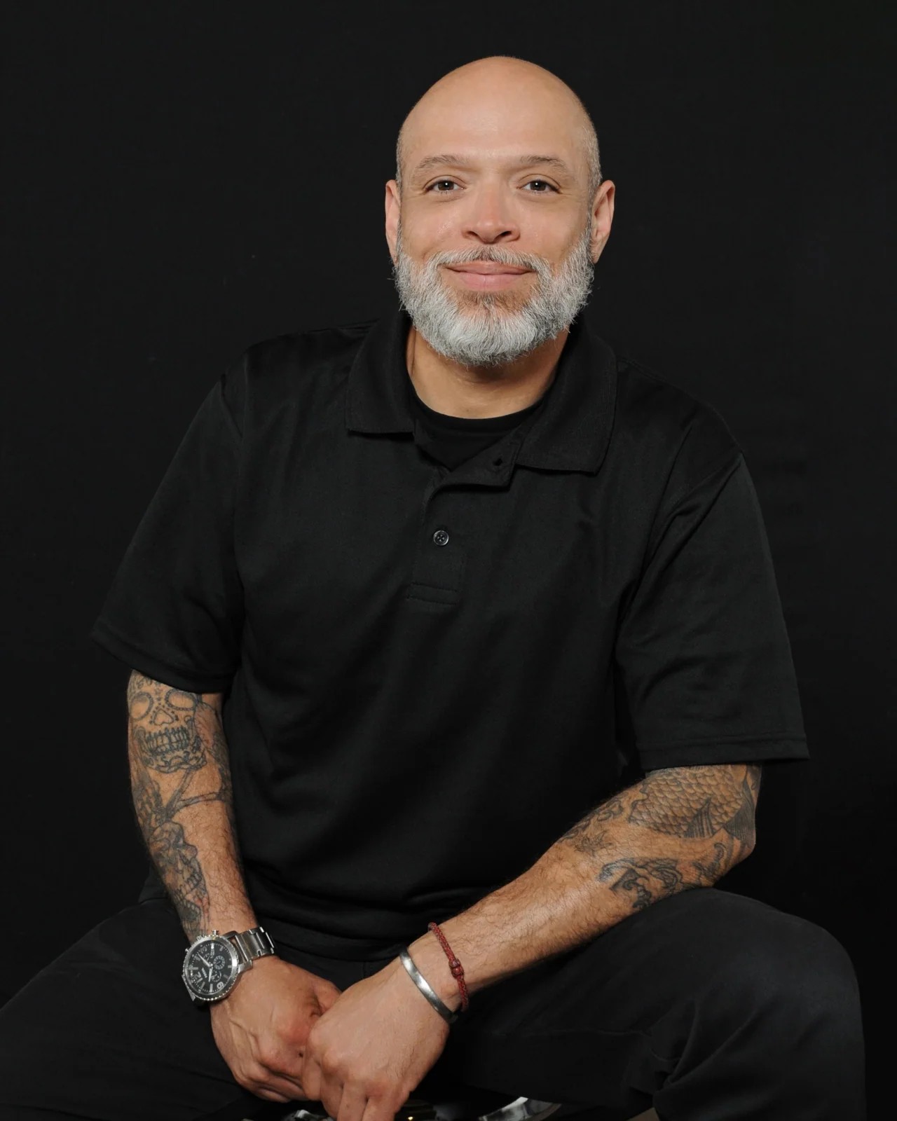Cruz Plumbing team member wearing a black company polo against a dark background