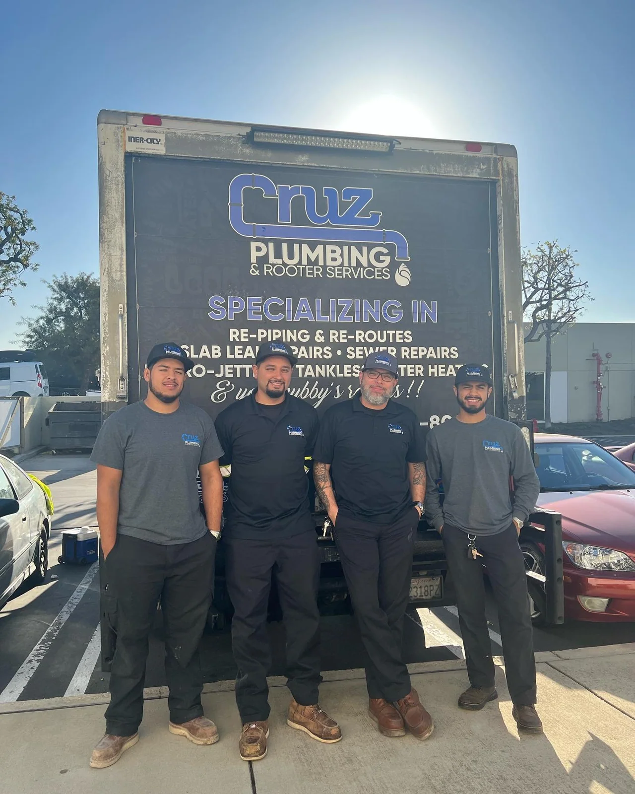 Four Cruz Plumbing team members standing in front of their service truck