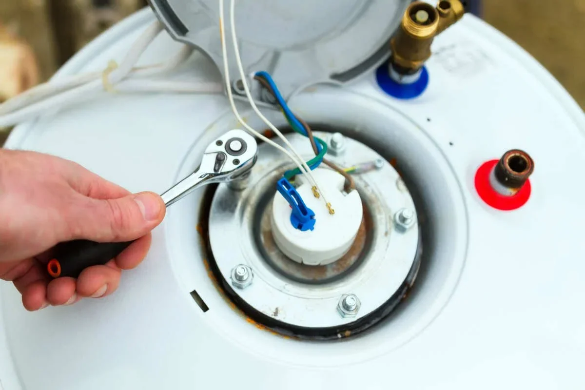 Technician adjusting a component on a water heater